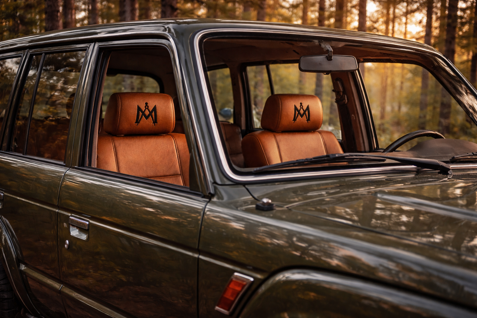 Custom headrest embroidery shown through vehicle window at sunset